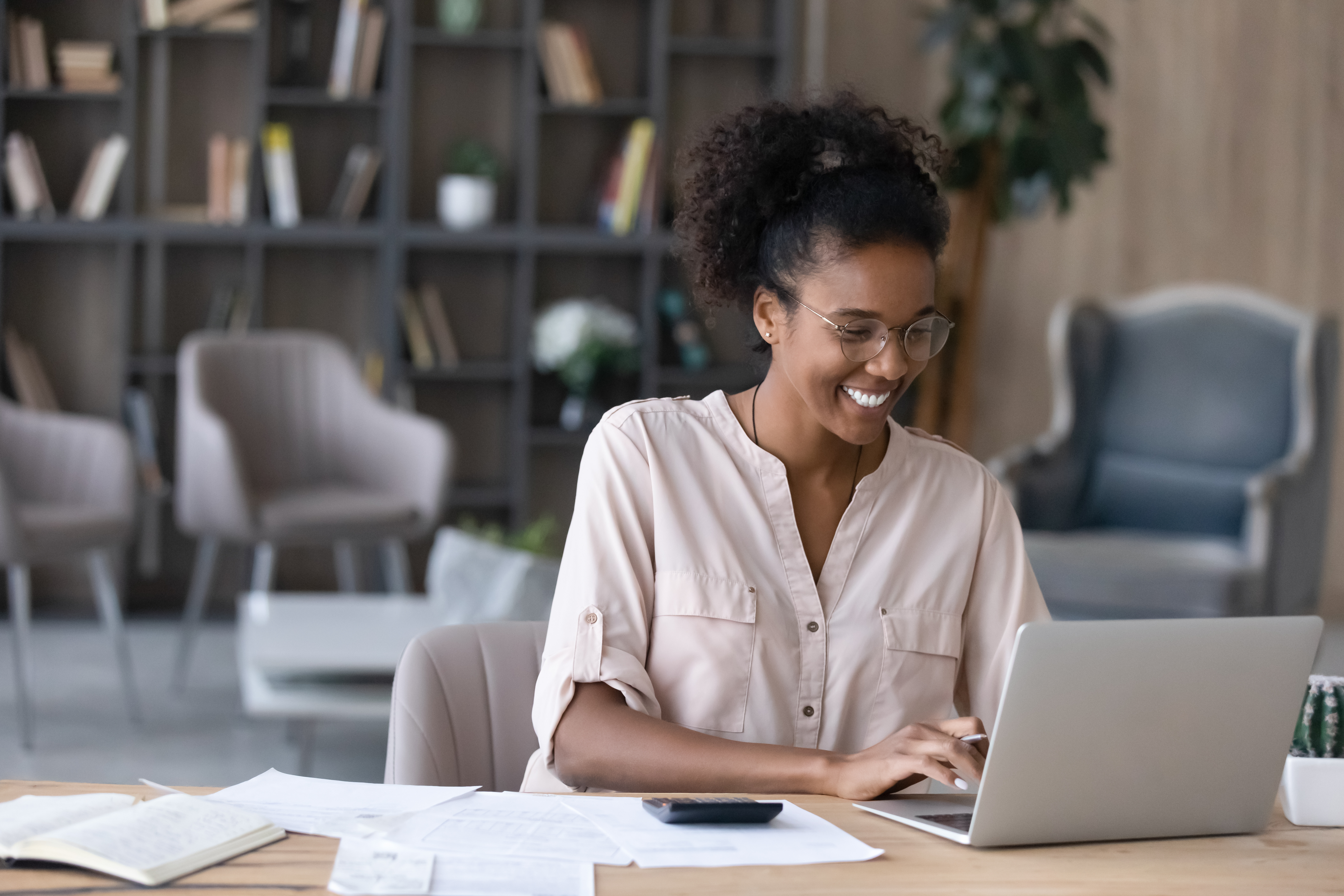 Woman smiling while working on laptop