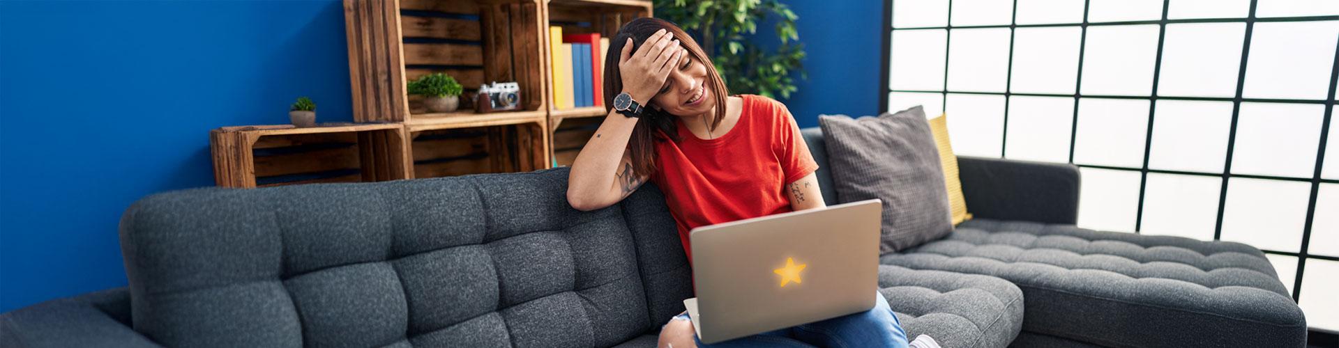 Woman on couch learning about scams on laptop