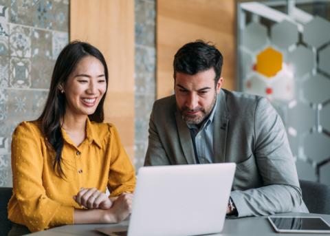Coworkers looking at laptop 